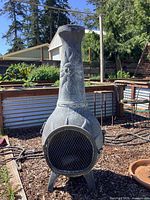 Full view of metal chiminea front with mesh door and sun motif