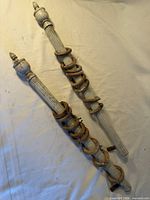 Pair of fluted wooden curtain rods with rings attached