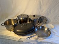 Group overview of cookware assortment on cloth backdrop