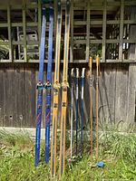 Full view of both ski pairs standing upright with three pairs of poles