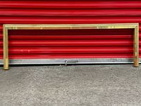 Front view of full brass fireplace surround against red background