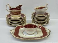 Stacked plates, creamer, teacup, square cake plate displaying overall set