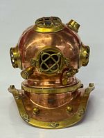 Front view of copper brass diving helmet showing grill viewport and collar