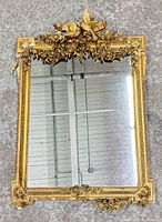 Front view of ornate giltwood mirror showing full design and crest