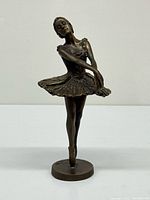 Front view of bronze ballerina sculpture on circular base
