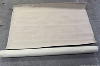 Carpet partially unrolled next to full roll