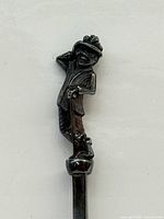 Full figural finial of dandy man with cane atop handle