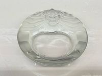 Top view of circular crystal ashtray showing lion head design and overall form