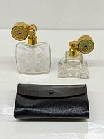 Both crystal perfume bottles with gold atomizers and black leather pouch