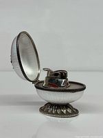 Egg table lighter open showing lighter insert and enamel interior