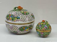 Both bonbonnières with lids on showing floral decoration and lattice design