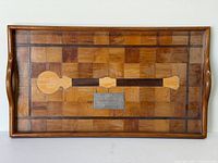 Top view of rectangular parquet wood tray with inlaid mace design and central plaque