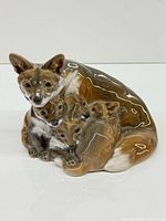 Full view of glazed porcelain mother fox and kits figurine