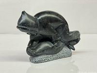 Front view of Inuit soapstone carving showing hunter over seal