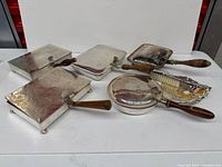 Group shot of all five silver plated silent butlers