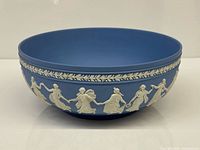 Side view of Wedgwood blue jasperware bowl showing white dancing figure relief and laurel band