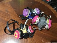 All three respirators laid out showing front view and filters