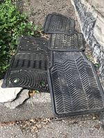 Four car floor mats laid out, showing two short and two long mats