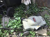 Full view of mower left side, handle folded, wheels visible