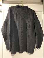 Front view of black cable-knit sweater