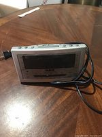 Front and top view of silver RCA digital clock radio with power cord