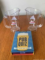 Full lot view showing two Coors Light pitchers and boxed Pub Quiz game