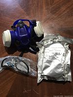 Drager respirator, sealed filter pouch marked A1B1E1-HG-P3 RD, and sealed safety goggles