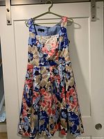 Front view of floral sleeveless dress hanging