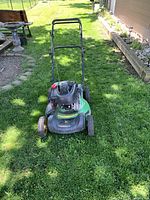 Full mower view from front showing deck, wheels, handle