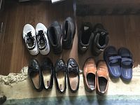 all seven pairs of men’s shoes laid out in two rows on floor