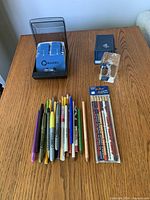 Lot overview showing Rolodex, paperweight, sealed pencils pack and loose writing instruments