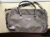 Front view showing logo patch, handles and shoulder strap