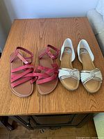 Both pairs of sandals side by side on table