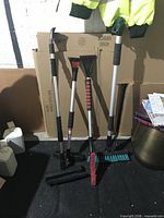 All four snow brushes and three loose attachments displayed upright and on floor