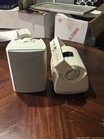 Front and side view of both speakers showing grilles and brackets