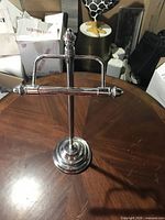 Front view of chrome freestanding toilet paper holder