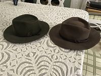 Top view of both felt fedora hats showing colors and ribbon bands