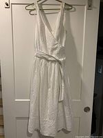 Full view of white eyelet dress on hanger