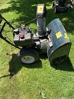 Side view of Yardworks snowblower showing engine, controls, chute, and flat front tire