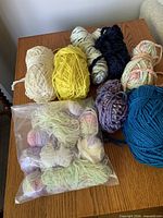 All yarn skeins and bag displayed on table