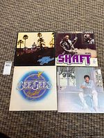 Four album covers laid out: Hotel California, Shaft, Bee Gees Greatest, Can't Slow Down