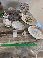 Group shot of six Carlsbad plates, Royal Albert creamer and sugar and other background plates on countertop