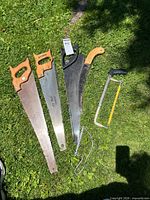All five saws laid on grass showing full view