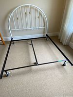 Headboard attached to metal frame showing wheels and overall form