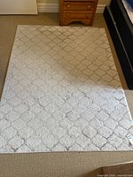Full view of beige Nambe area rug showing geometric trellis pattern