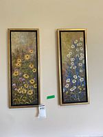 Both framed floral paintings side by side on wall