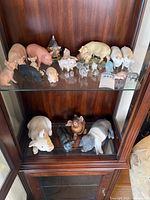 Overview of two shelves showing full pig figurine collection