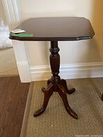 Full view of square wooden accent table showing pedestal and legs
