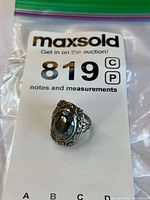 Front view showing oval faceted black stone and filigree bezel