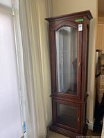 Full view of wooden curio cabinet showing overall design and proportions